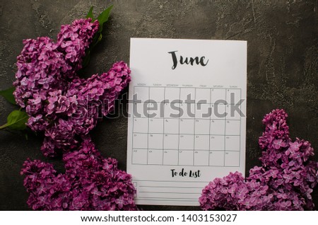 june calendar with flowers on wooden background