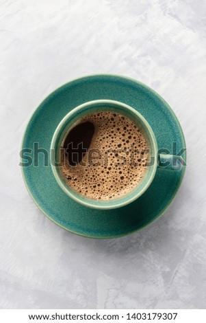 A cup of black coffee, shot from the top with a place for text on an abstract gray background