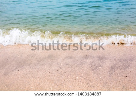Soft wave of blue ocean on sandy beach with copy space background.