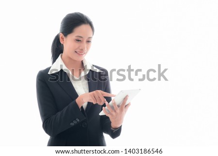 Asian business woman in a black suit with tablet, looks smart about 25s years old. She was delighted when receiving good news from email in tablet making her cheerful, online shopping white background