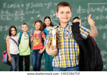 Students with backpacks and books in the classroom Royalty-Free Stock Photo #1403186759