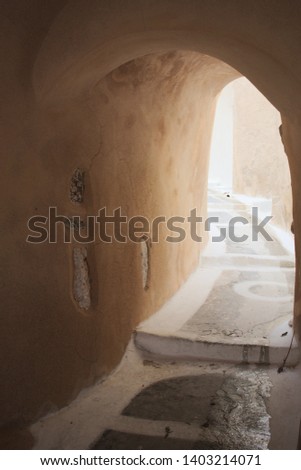 Greece, the island of Santorini. The inland town of Emporio. Part of the medieval Kasteli, a fortified area that acted as a castle, although it is made up mostly of houses. Sunlight in a narrow alley.