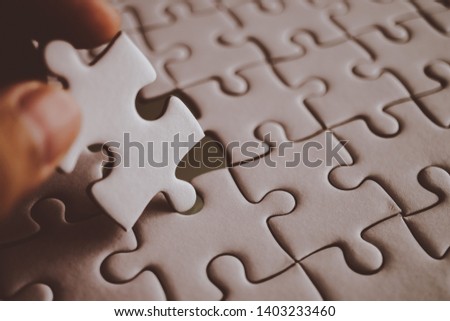 last piece of white plain jigsaw holding by hand, step of success concept