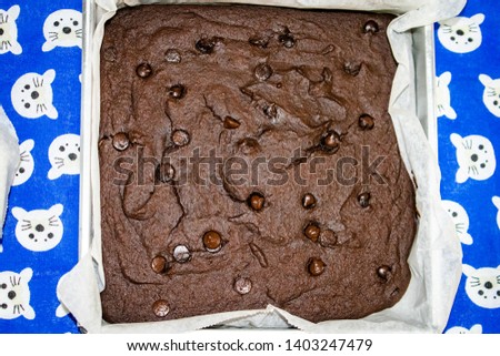 bright close up picture of cooked brownie cake on a blue and white pattern table cloth