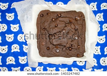 bright close up picture of cooked brownie cake on a blue and white pattern table cloth