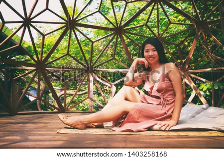 Vintage Photography style of Beautiful Asian woman in the park with wooden dome balcony background, outdoor portrait.