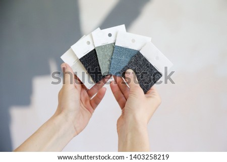 Young woman choosing a perfect shade of grey for walls in her new home