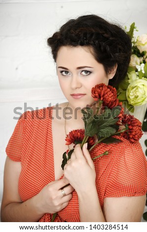 portrait of a beautiful brunette with red flowers