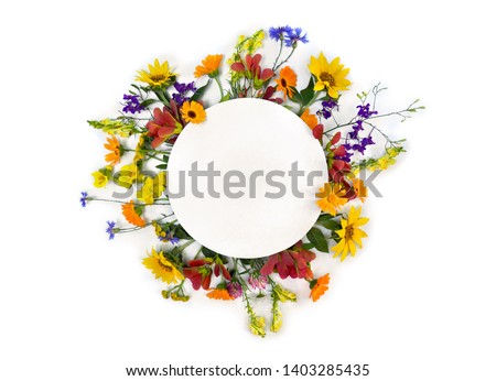 Creative decoration summer flowers sunflowers, calendula, linaria, chamomiles, blue cornflowers with white circle paper card note with space for text on white background. Top view, flat lay