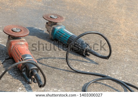 Angle grinder isolated on cement floor background. Construction concept.