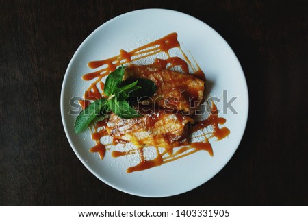 Beautiful background of pancakes with caramel on a white plate on a wooden table. The concept of food. Place for text.