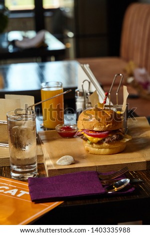 American reciped food presentation - traditional burger with fries. Restaurant interior background