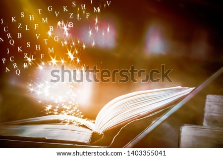 This Open book on table have text English alphabet Floating above the book and blur bookshelf background. openbook concept