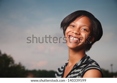 Portrait of beautiful happy African American teenage girl smiling  at twilight