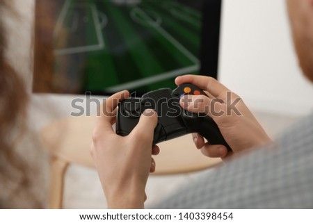 Young man playing video games at home, closeup