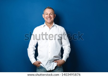 Handsome middle-aged man on color background