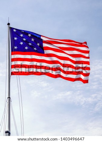 American flag with 15 stars and 15 stripes, a replica that commemorates the successful repulse of a British naval bombardment during the War of 1812, flying over Fort McHenry, Baltimore, Maryland, USA