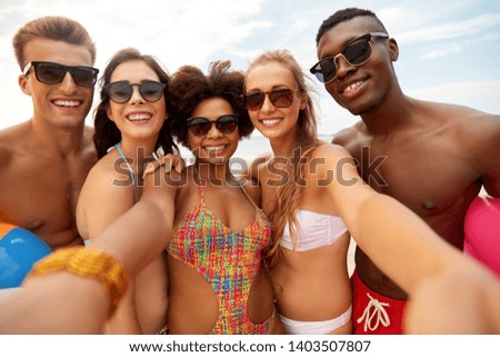 friendship, summer holidays and people concept - group of happy friends taking selfie on beach
