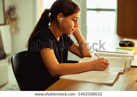 Teenager girl doing homework	in her room