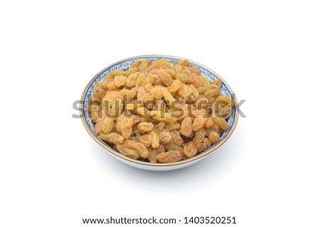 Candied fruit of golden raisins in porcelain bowl on white background,studio shot side view
