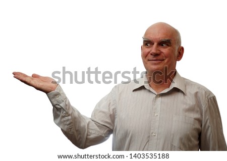 An elderly, cheerful man shows his palm with empty space and admires it himself.