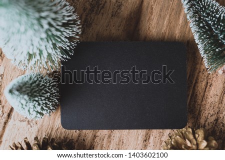 Top view of blank blackboard with xmas tree and gold pine cone on grunge wood table .winter holiday greeting card.space for display of design or content.