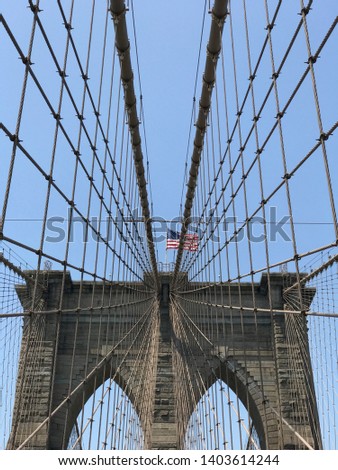 USA flag on top of bridge with steel cables in viewing up perspective