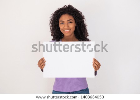 Cheerful black woman holding white banner and copy space