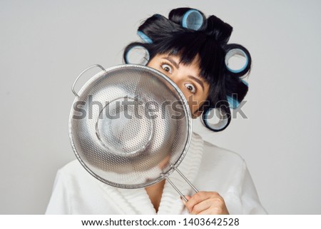     woman with curlers holding sieve                          