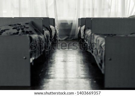 Long room with beds on the sides. Bedroom in the orphanage Royalty-Free Stock Photo #1403669357