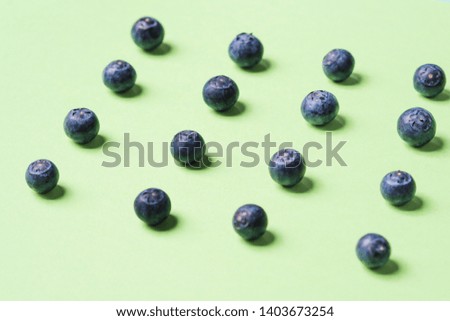 Pattern of fresh blueberries in on pastel green background. Healthy breakfast concept