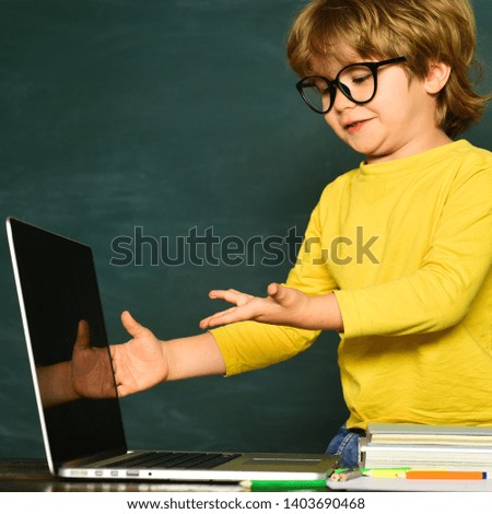 Kid is learning in class on background of blackboard. Science education concept. Cute little preschool kid boy in a classroom. September 1