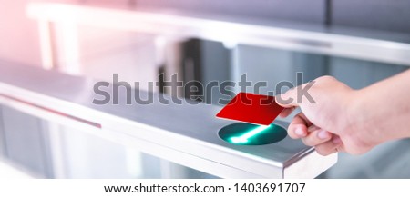 Male hand using smart card to open automatic gate machine in office building