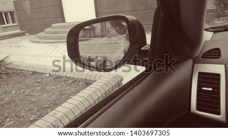 Texture, background, wallpaper, street view image and left side mirror of an expensive modern car from inside the cabin in the middle of a clear day in sepia decor.
