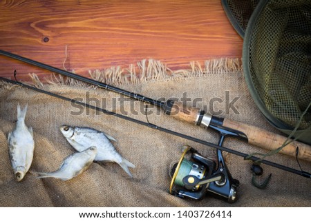 Fishing tackle-fishing rods, hooks, floats and lures on wooden background
