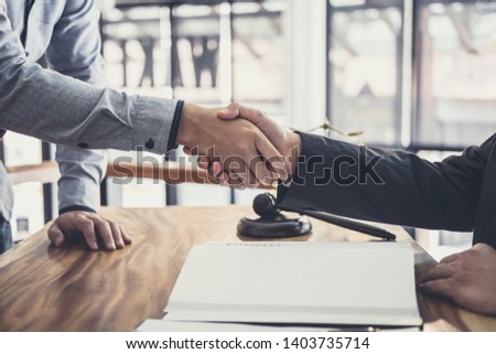 Handshake after good cooperation, Businessman Shaking hands with Professional male lawyer after discussing good deal of contract in courtroom.