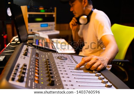 asian male professional sound engineer working in recording, broadcasting, editing studio