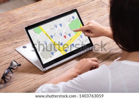Close-up Of A Woman's Hand Using GPS Navigation Map On Digital Laptop