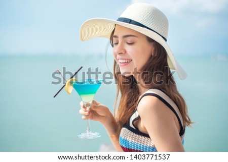 Beautiful woman is drinking ice summer drink in the beach, summer concept 