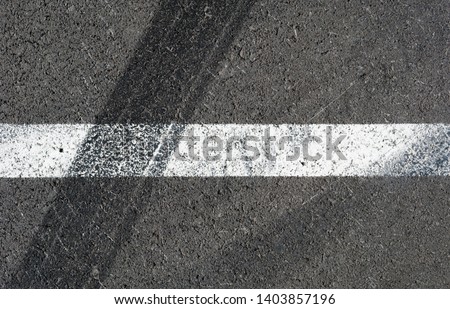 Asphalt texture with white line and tire marks . Top view Royalty-Free Stock Photo #1403857196