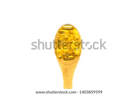 Omega 3 fish oil capsules on wooden spoon. Top view