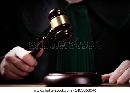 justice and law concept.Male judge in a courtroom striking the gavel