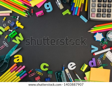 Back to School concept school and office supplies on a black background all stationery items with black board