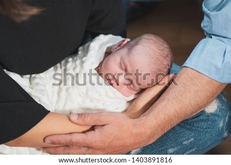 Cropped image of a cute adorable baby sleeping together his parents. Family, new life, childhood, beginning concept.