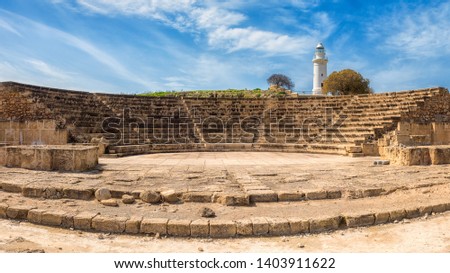 Ancient Odeon amphitheatre in Paphos Archaeological Park (Kato Pafos), harbour of Paphos, Cyprus, panoramic view. Scenic landscape with ruin of medieval architecture, lighthouse and blue sky Royalty-Free Stock Photo #1403911622
