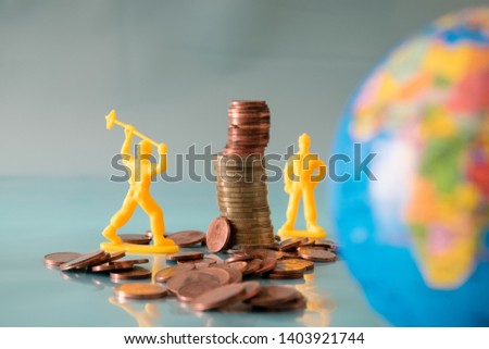 Toy workers destroy a tower of coins. No capitalism concept. Royalty-Free Stock Photo #1403921744