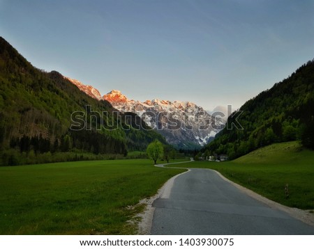 The Logar valley (Logarska dolina) at sunset. Famous place in Slovenia. Sunshine on moutains. Road crossing the valley. Picture was taken on 20th of May 2019.