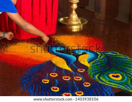 Scene in hindu temple in Kuala Lumpur. Artist creating bright picture on a floor