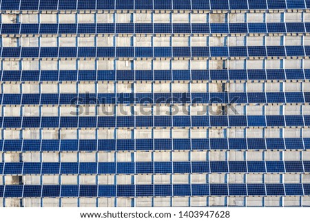 Top view of blue shiny solar photo voltaic panels system producing renewable clean energy abstract background.