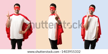 Set of Superhero man with mask and red cape showing and lifting a finger in sign of the best on colorful background